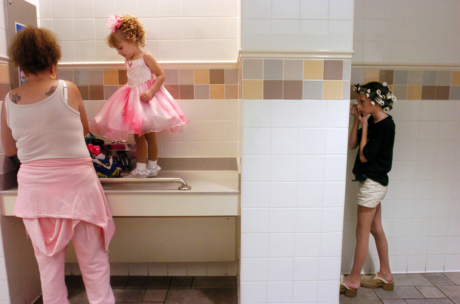 Linda Wilson, left, dresses her daughter, Diane, 4, while Storts applies her eye makeup in the bathroom of the Gulf View Square Mall before competing in the Little Miss-Mr. Octoberfest Pageant.  : Little Miss Sweet Pea : Madison | Milwaukee | Chicago | Writer | Photographer | Keri Wiginton | Portrait photography | Travel | Corporate | Photojournalist | Editorial | Environmental