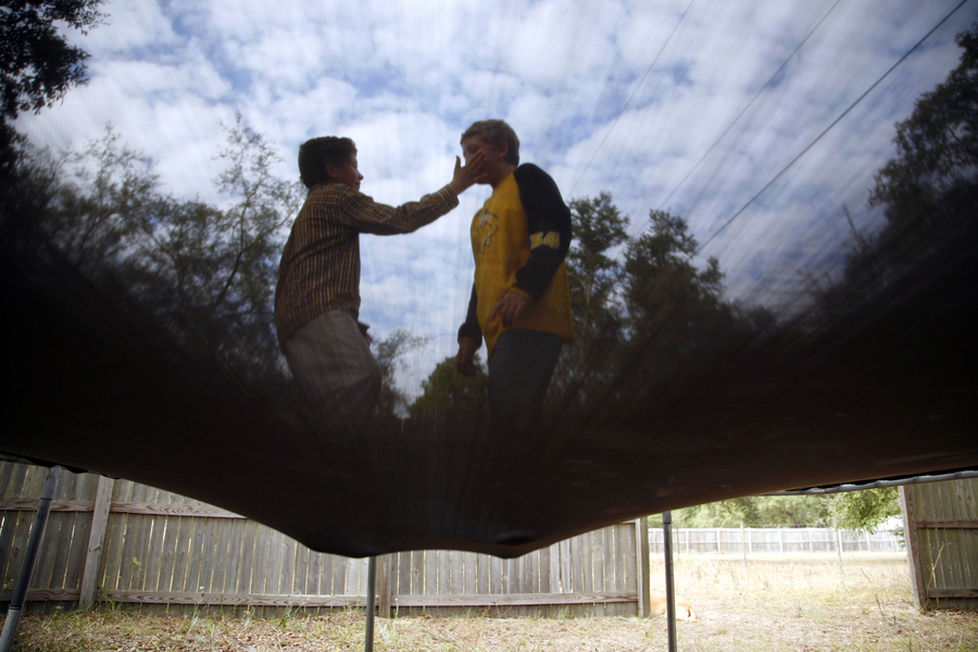 Ryan Moran, 12, reaches out for his twin brother Anthony while the two jump on the trampoline outside their house in Interlachen, Fla. Ryan is severely autistic and cannot sit still or avoid unintelligible outbursts.  : Moments : Madison | Milwaukee | Chicago | Writer | Photographer | Keri Wiginton | Portrait photography | Travel | Corporate | Photojournalist | Editorial | Environmental