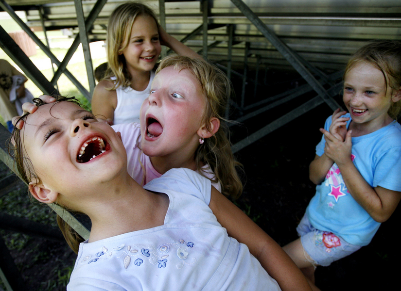 Marissa Hawk, 6, front left, laughs while Katie Hedges, 7, pretends to be an alien in a park in Spring Hill, Fla.  : Moments : Madison | Milwaukee | Chicago | Writer | Photographer | Keri Wiginton | Portrait photography | Travel | Corporate | Photojournalist | Editorial | Environmental