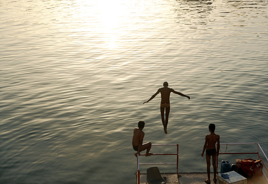 A group of young men take a swim in Lake Pichola as the sun sets in Udaipur in the state of Rajasthan in western India. : Moments : Madison | Milwaukee | Chicago | Writer | Photographer | Keri Wiginton | Portrait photography | Travel | Corporate | Photojournalist | Editorial | Environmental