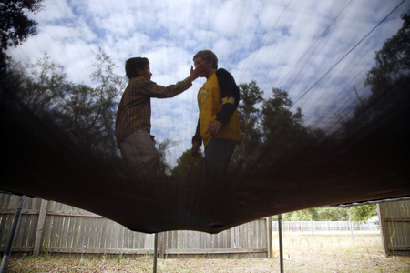 Ryan Moran, 12, reaches out for his twin brother Anthony while the two jump on the trampoline outside their house in Interlachen, Fla. Ryan is severely autistic and cannot sit still or avoid unintelligible outbursts. 