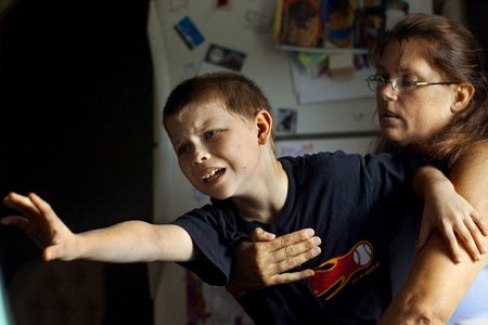 Matthew Peck, 7, reaches away from his mother Cathy Peck as she tries to get him to finish his math lesson. Matthew, who has been diagnosed with Attention Deficit Hyperactivity Disorder, Dyslexia and exhibits anger and rage episodes, has trouble concentrating. 